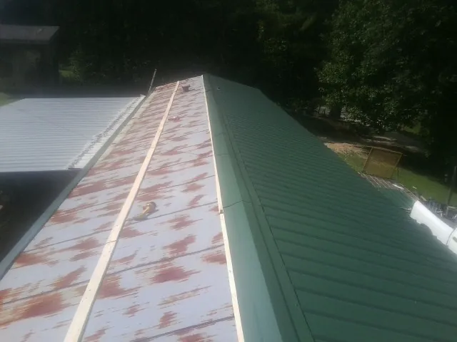 Old rusted panels beside newly installed green metal roofing — Wind Damage Roof Repair by Roofing Brothers in Litchfield